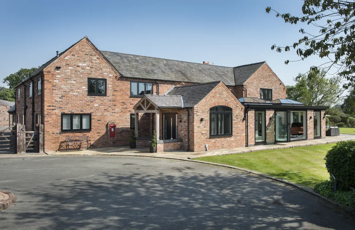 A brick barn conversion with dark aluminium windows and doors