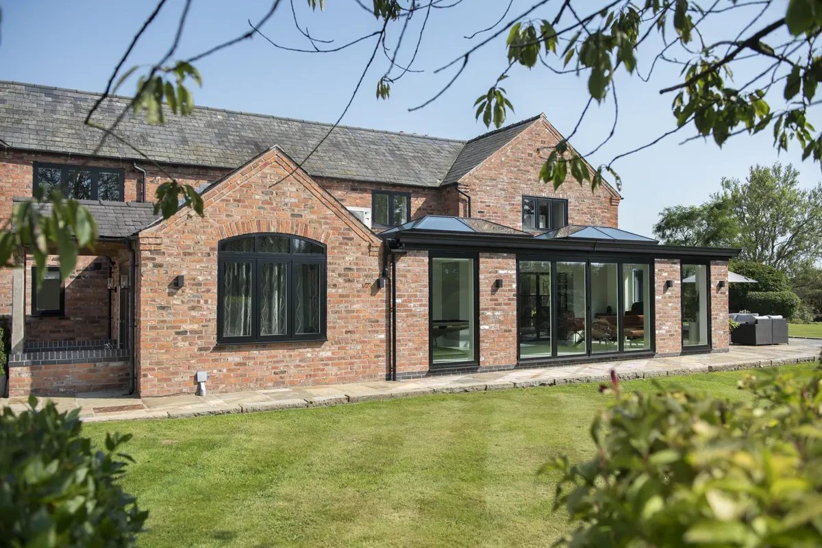 A long run of aluminium windows on a single-storey brick extension