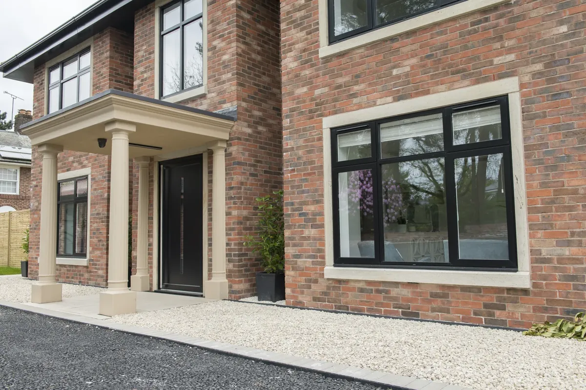 Black aluminium windows on a large brick and render house