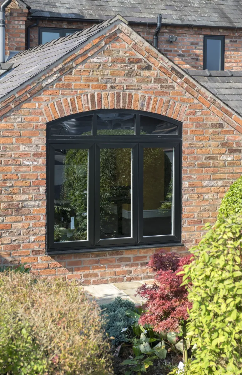 Flush casement windows with dummy opening sashes in a brick arch
