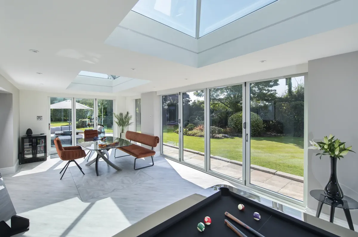 Bifold doors open onto a garden from a games room