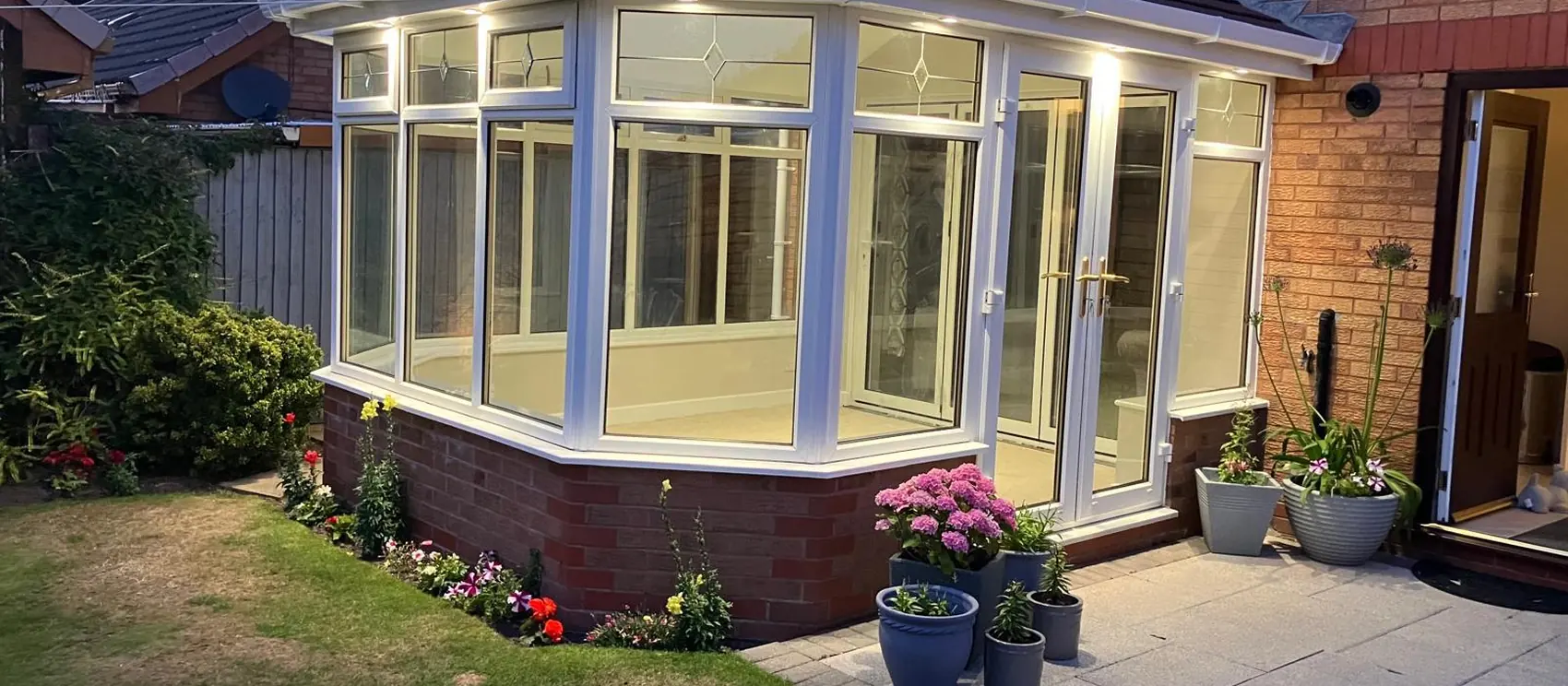The finished conservatory with its new tiled roof, lit at dusk