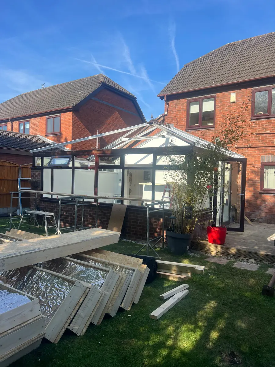 The old roof panels stacked on the lawn after removal