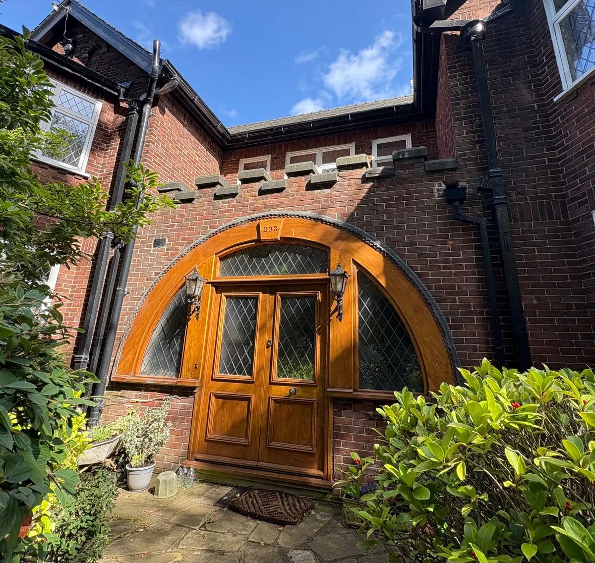 The arched hardwood entrance door after restoration