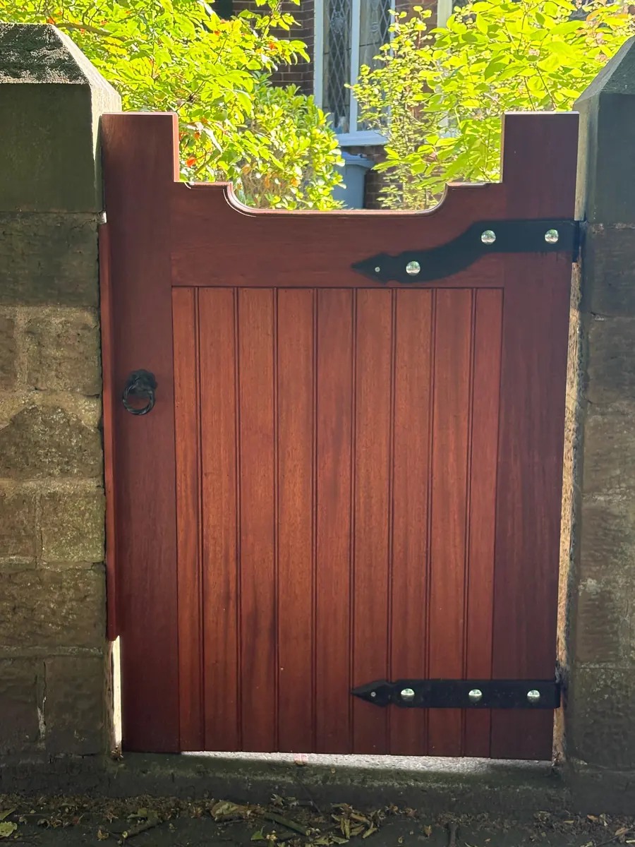 The new hardwood gate hung in the stone opening