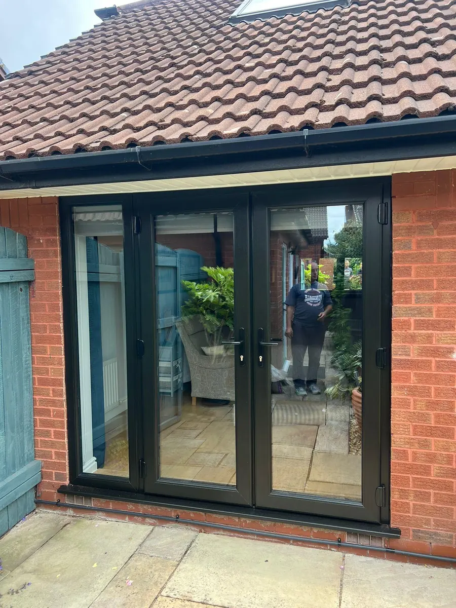 The new black uPVC French doors with fixed side frames