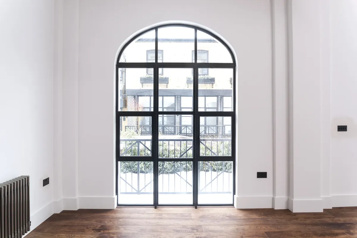 An arched steel-look screen and doors to a balcony