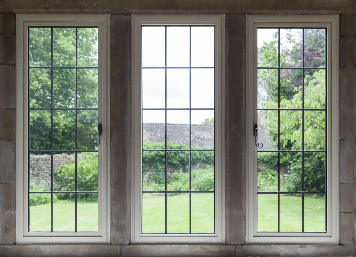 A three-light leaded steel-look window in a stone surround