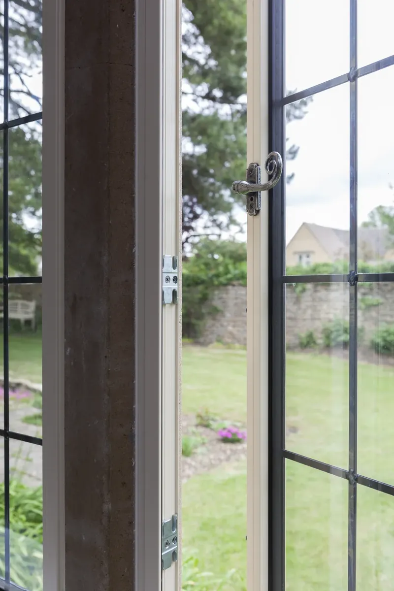 A steel-look casement window open onto a garden
