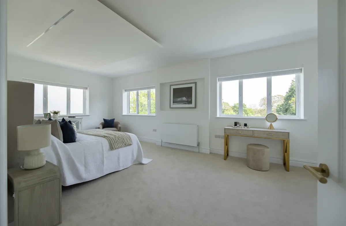 A bedroom with three windows along one wall