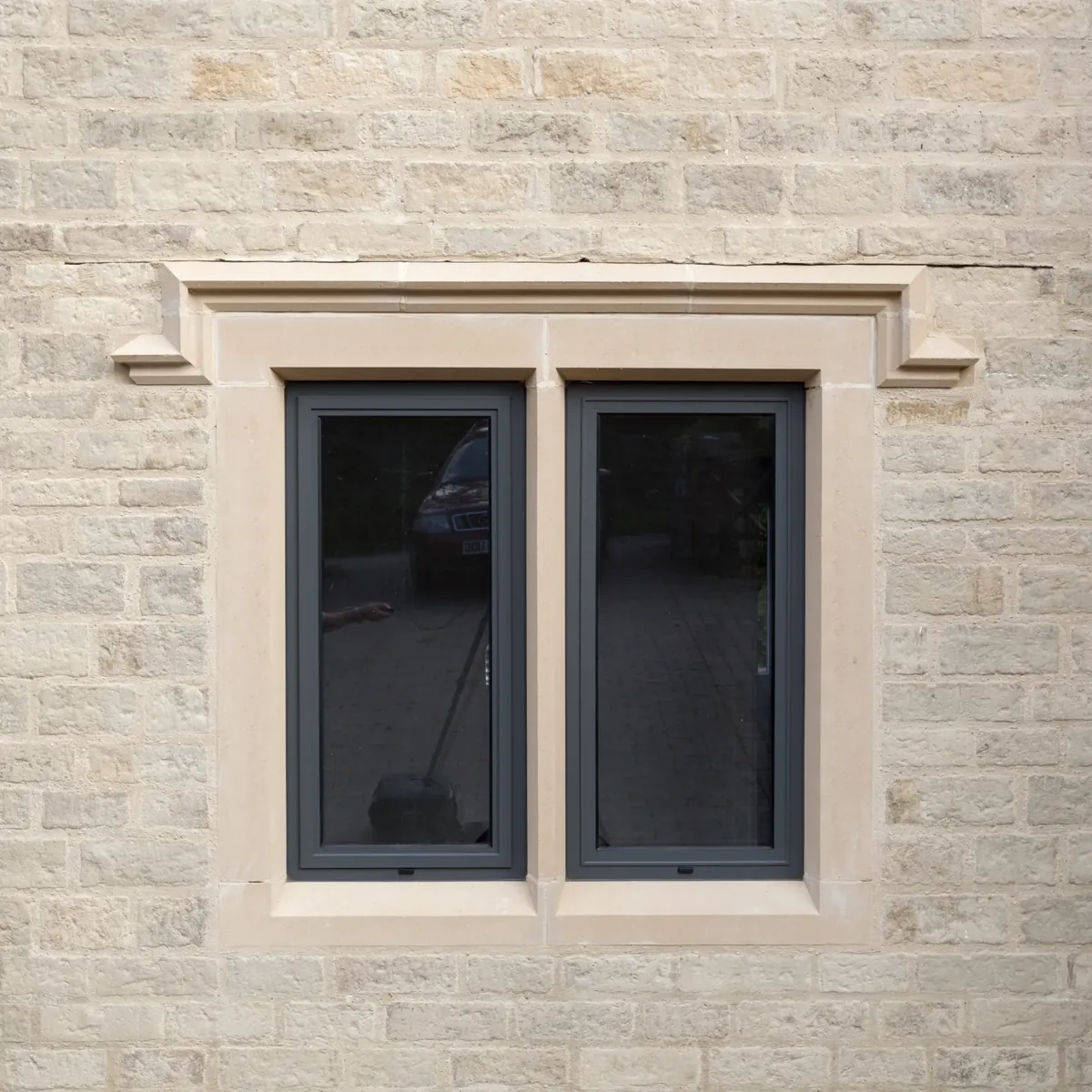 A two-light window in a dressed stone surround